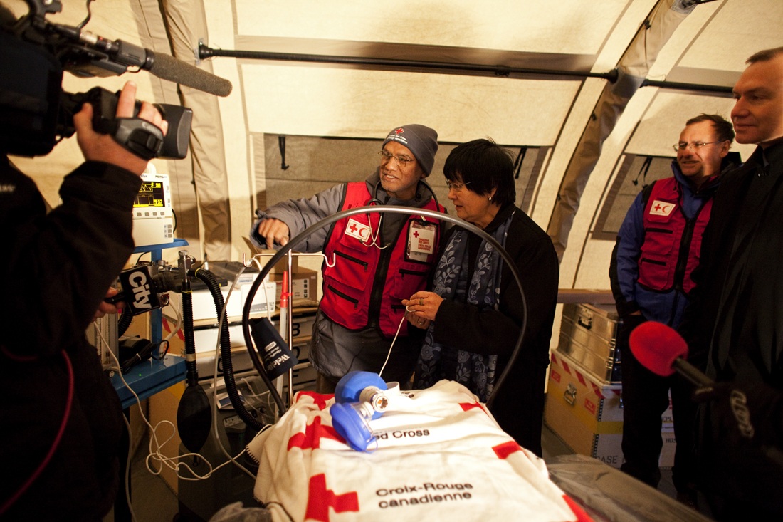 Media film the Honourable Beverley J. Oda, Minister of International Cooperation, as she tours the field hospital facilities. / Photo credit: Johan Hallberg-Campbell