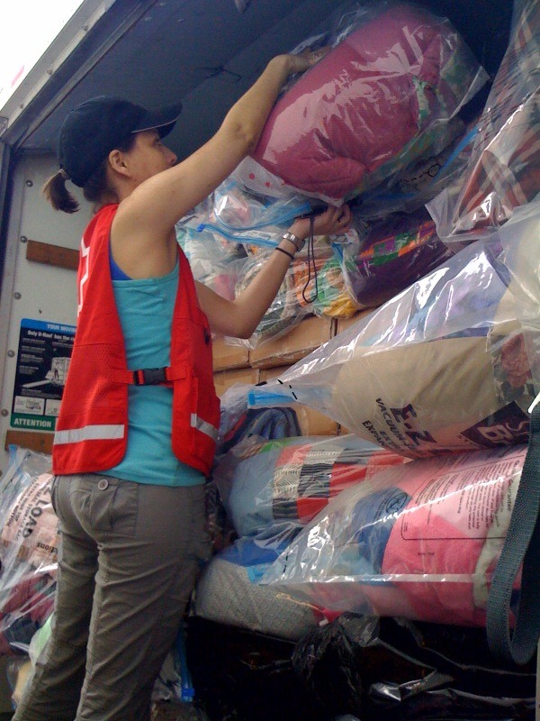 Red Crosser loads van with cots, blankets & comfort kits bound for fire-affected communities on Sunday.