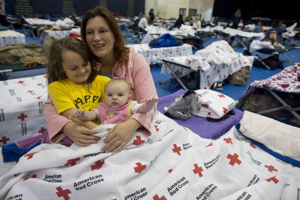 Candice Haugland of Seaside Heights, N.J., and her niece, eight-year-old Amy Hoopingarner and two-month-old Nora Remington, are settling in at the Red Cross shelter in the Pine Belt Arena in Toms River, N.J. A steady flow of evacuees has been filling the shelter since Sunday; shelter capacity is 1,100.
<p>Photo: Les Stone/American Red Cross