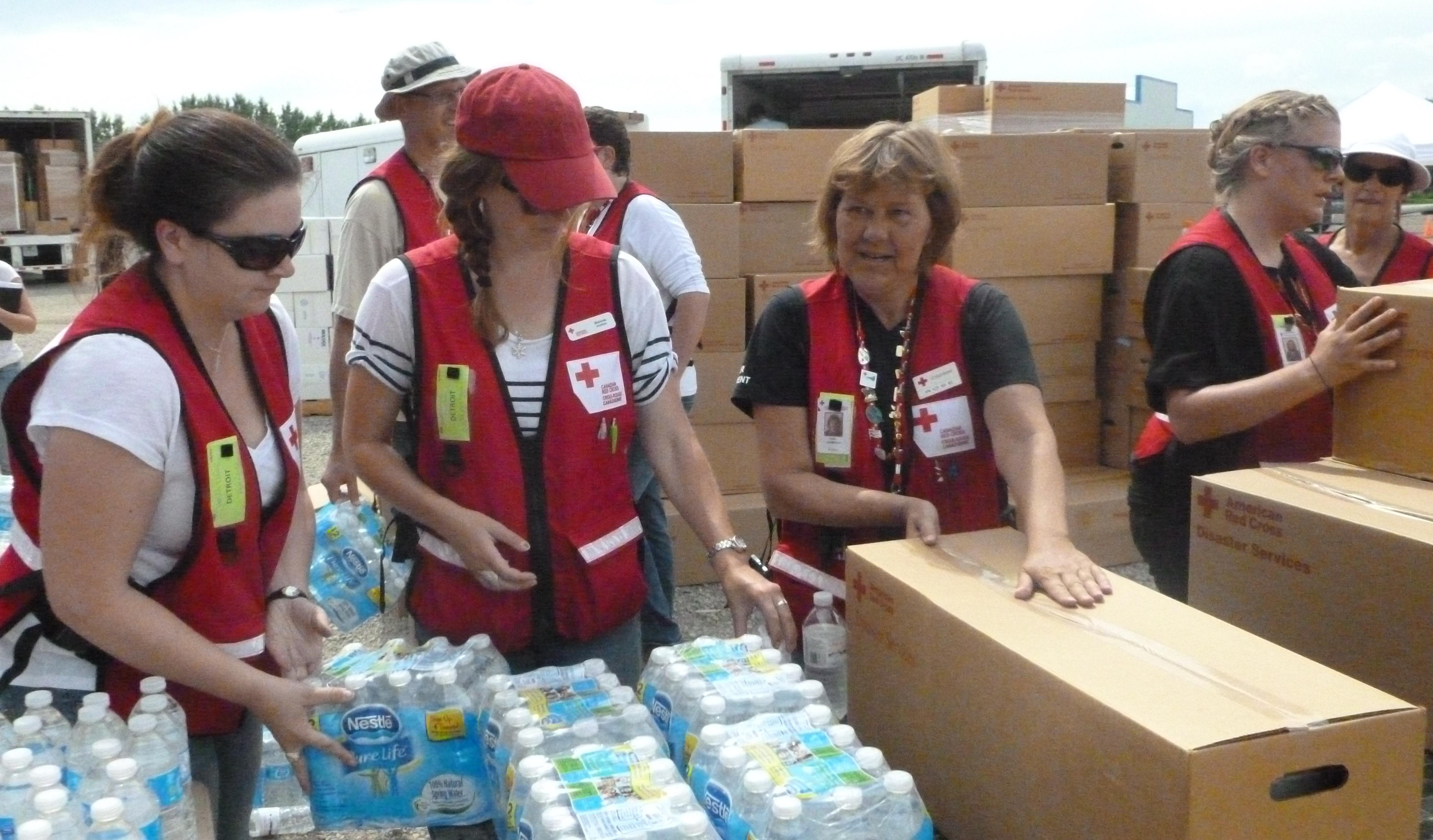 Canadian Red Cross volunteers distributing clean-up kits and water