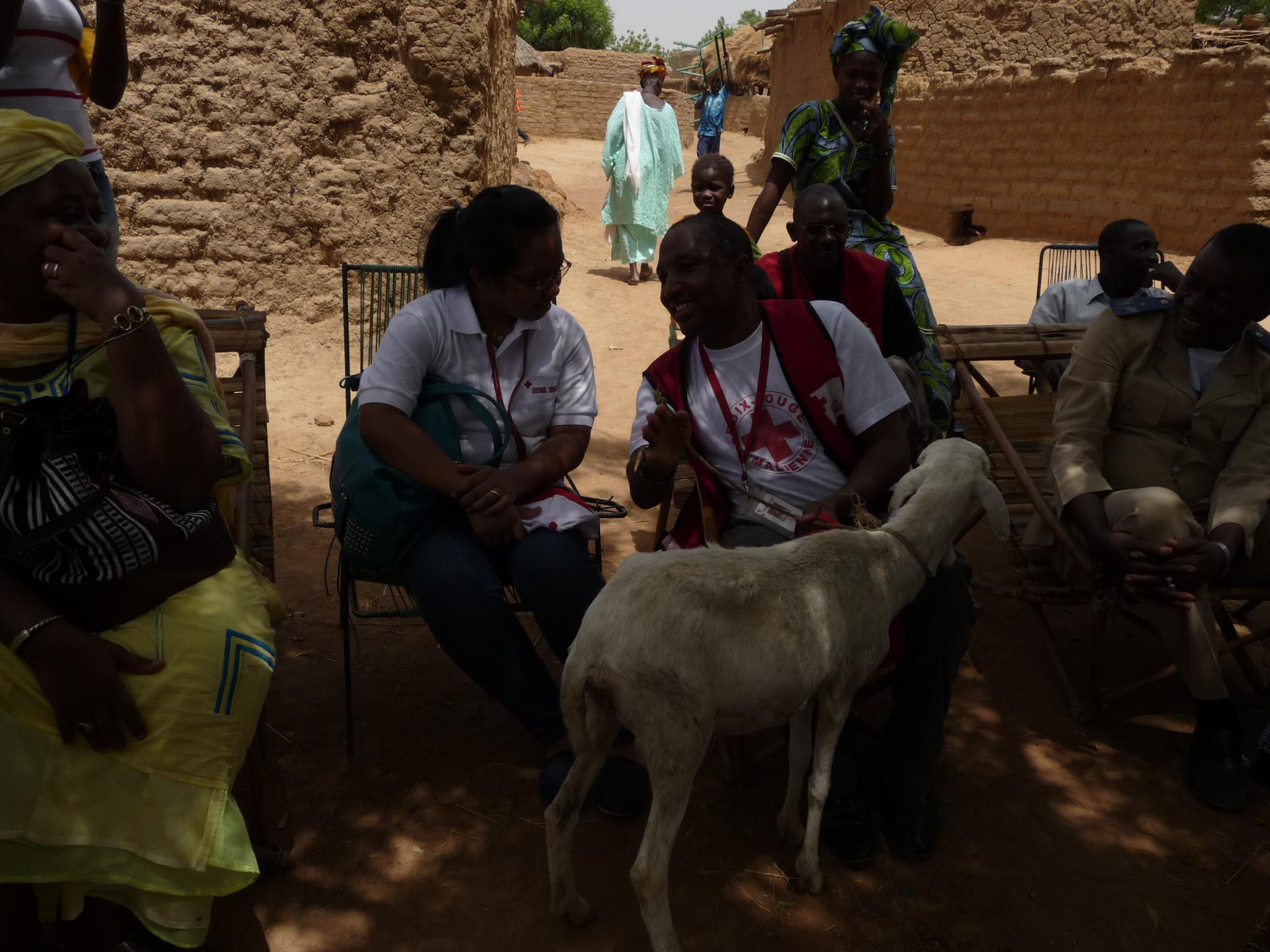 Villagers offer a goat to a visiting Red Crosser
