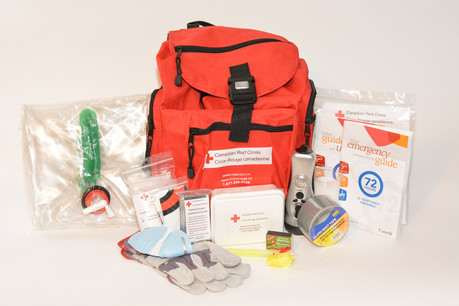 a Red Cross emergency kit, red backpack surrounded by essential first aid items