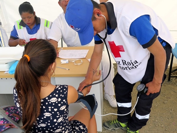 Ecuador Red Cross paramedic student takes blood pressure 