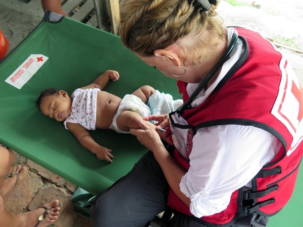 Doctor examining a baby with a rash at a mobile clinic 