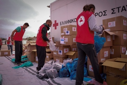 Members of the Hellenic Red Cross prepare supplies for distribution