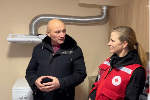 Two individuals engage in conversation inside a unit refurbished by the Canadian Red Cross.