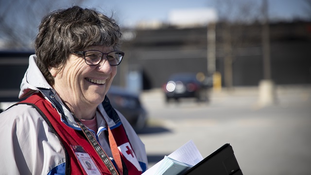 Une femme portant un gilet de la Croix-Rouge Canada souriante