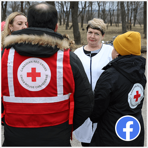 Canadian Red Cross staff speak to Olga Chepurna, head of medical and obstetrics unit on the street