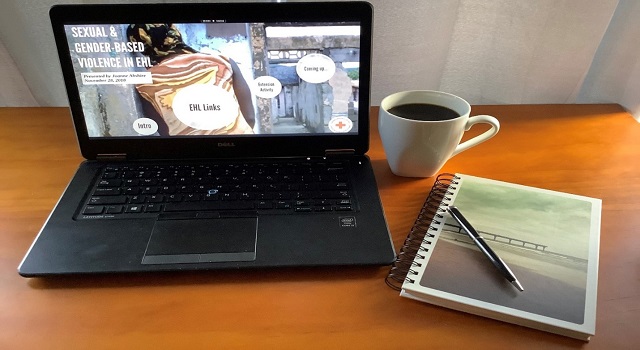 laptop on a desk, with a coffee and notebook