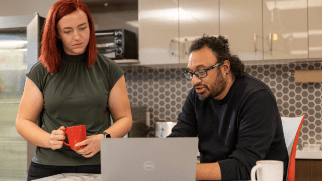 Two people reviewing information about opiod harm reduction on a laptop