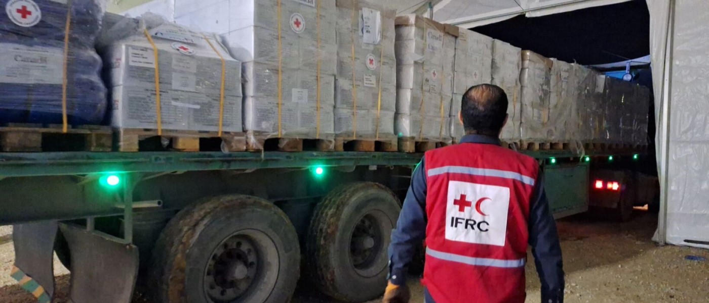 An IFRC employee supervises the arrival of a truck loaded with humanitarian aid in the Middle East