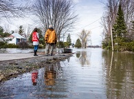 Two people beside a flooded road
