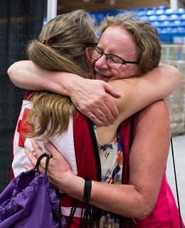 Canadian Red Cross volunteer hugs a woman at a shelter