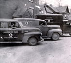 Three Red Cross cars aligned on the street during the Second World War