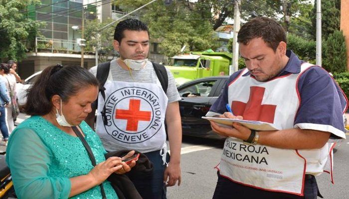 Red Cross workers speak with a woman