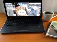Laptop, Notepad and cup of coffee on a desk