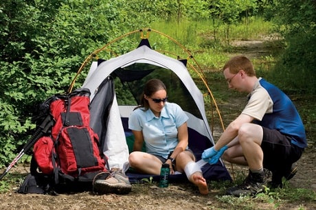 A man and woman in front of a tent outdoors