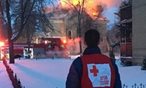 Red Cross volunteer watching a house fire