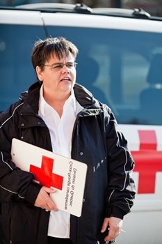 Claudie Laberge standing in front of a Red Cross vehicle.