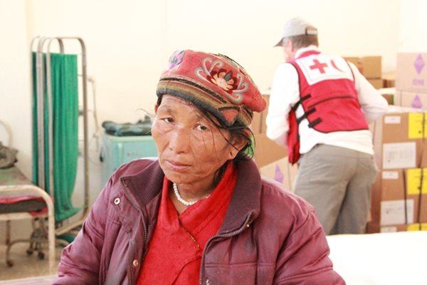 Nepalese woman with Red Cross worker in the background