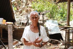 Standing amongst the rubble that was once her house, 73-year-old Aichie Akitekit looks almost angelic in a long white cotton dress