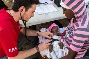 Canadian aid worker provides medical care to an infant in Haiti.