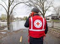 A Red Cross volunteer surveys a flooded road