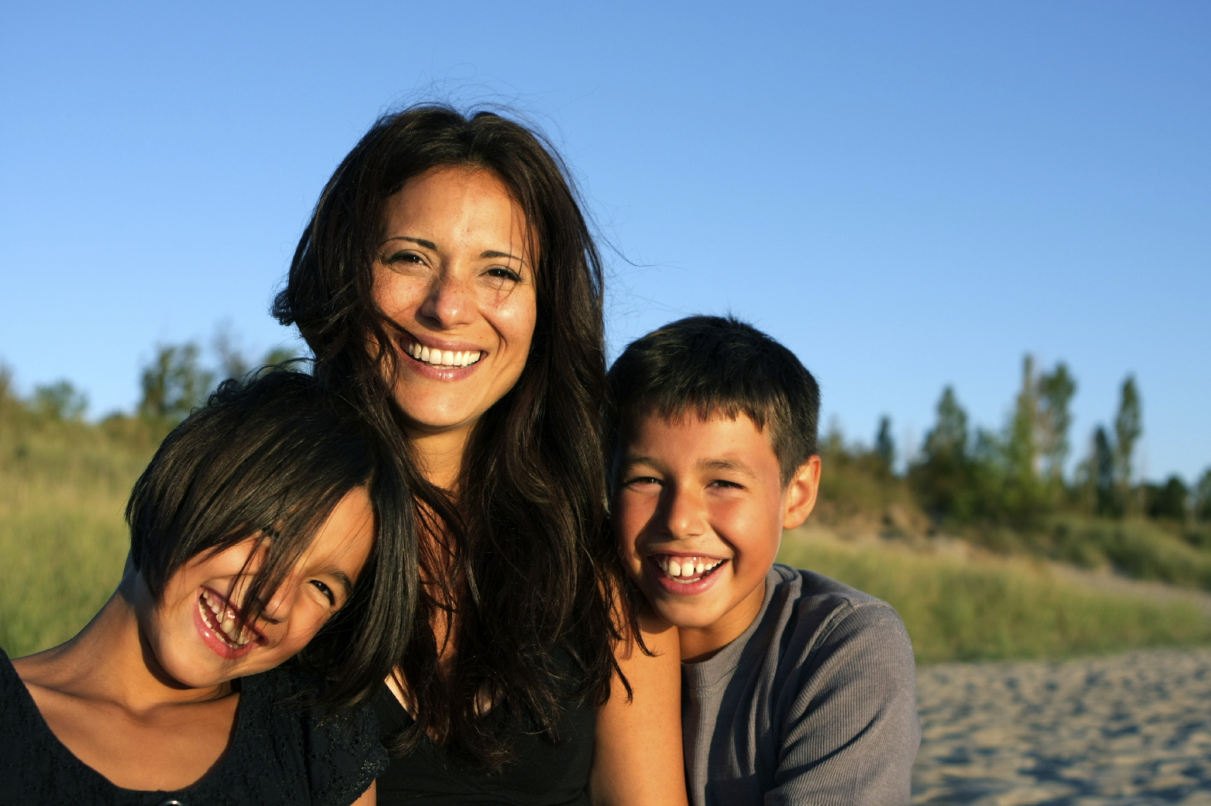 Indigenous mother smiles with her two kids.