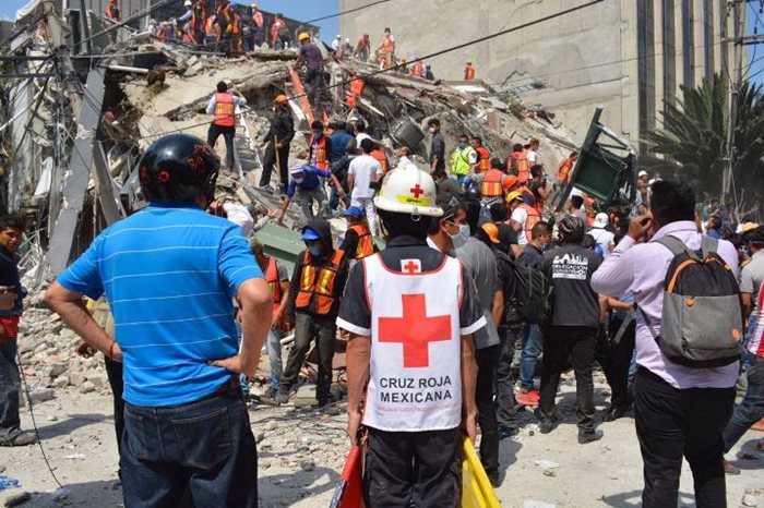 Search and rescue workers look for people in a collapsed building