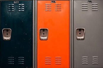 Close-up on three lockers: one painted black, middle one painted orange, and right one painted grey