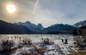 A frozen lake with people skating on it.