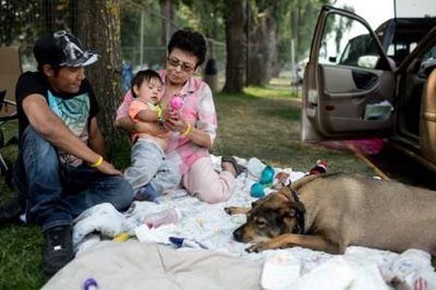Wildfires evacuees Marlene, her son, and grandchild outside the Kamloops evacuation centre
