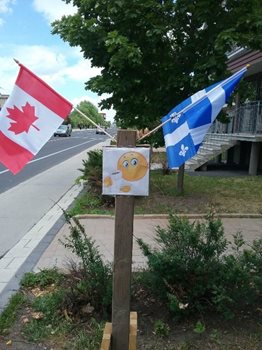 A Canadian flag with a province of Quebec flag outside the facility.