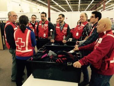 Red Cross volunteers meet before greeting refugees arriving in Canada