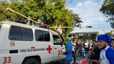 A Red Cross ambulance in a crowded area