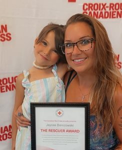 Jaycee with her mom, holding Jaycee's Rescuer Award.