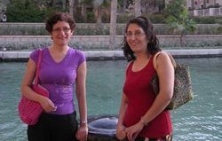 Two women standing beside a pool