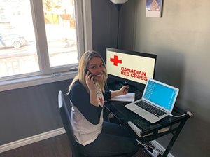 Jessica Siddall, Canadian Red Cross emergency management coordinator, sitting at a computer.