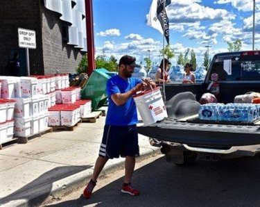 A man loads clean-up supplies in a truck after re-entering Fort McMurray