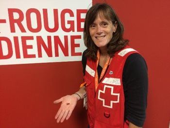 Manon Michaud, Canadian Red Cross volunteer, holding one of Aileen's glass hearts