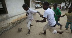 kids play soccer on a sand street
