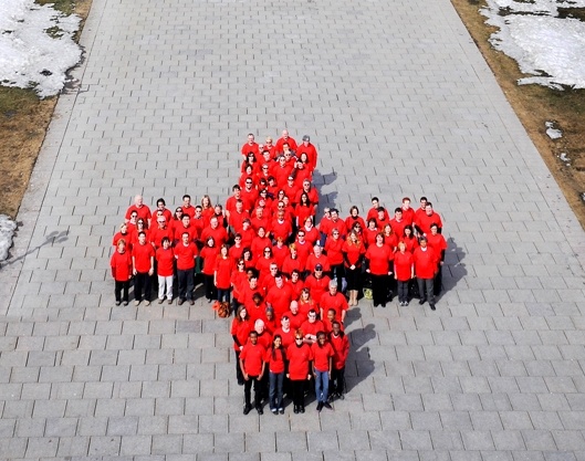 An aerial shot of Canadian Red Cross staff and volunteers wearing red shirts, in the formation of the Red Cross cross