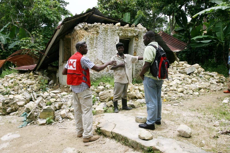 Francois Janes (centre) stands in front of what used to be home for himself and his wife and nine children in Makary, high in the mountains above Jacmel.