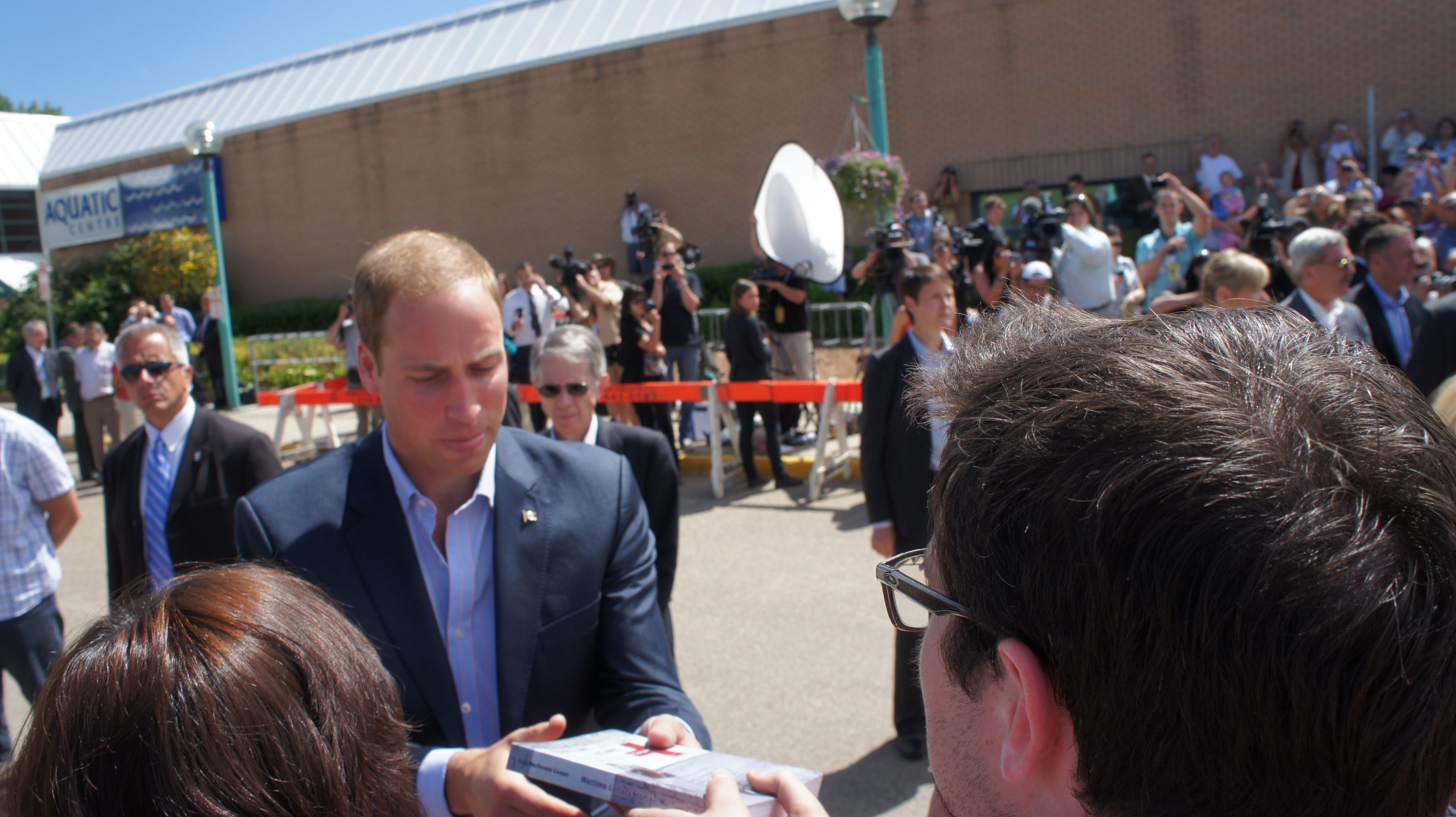 Prince William accepts Red Cross book from volunteer Nick Conradi.
