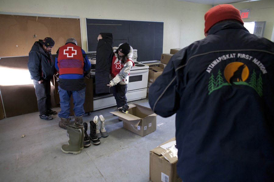 Canadian Red Cross volunteers working with community members preparing supplies for distribution