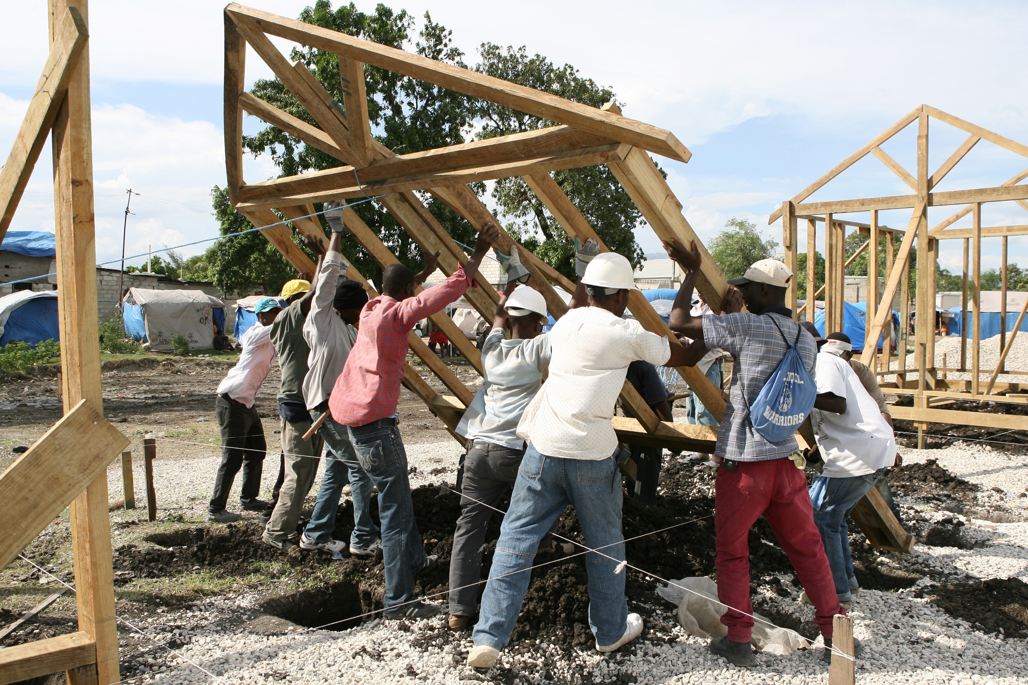 Workers and Red Cross carpenters erect a transitional shelter in L'Annexe de la Mairie, Port-au-Prince.