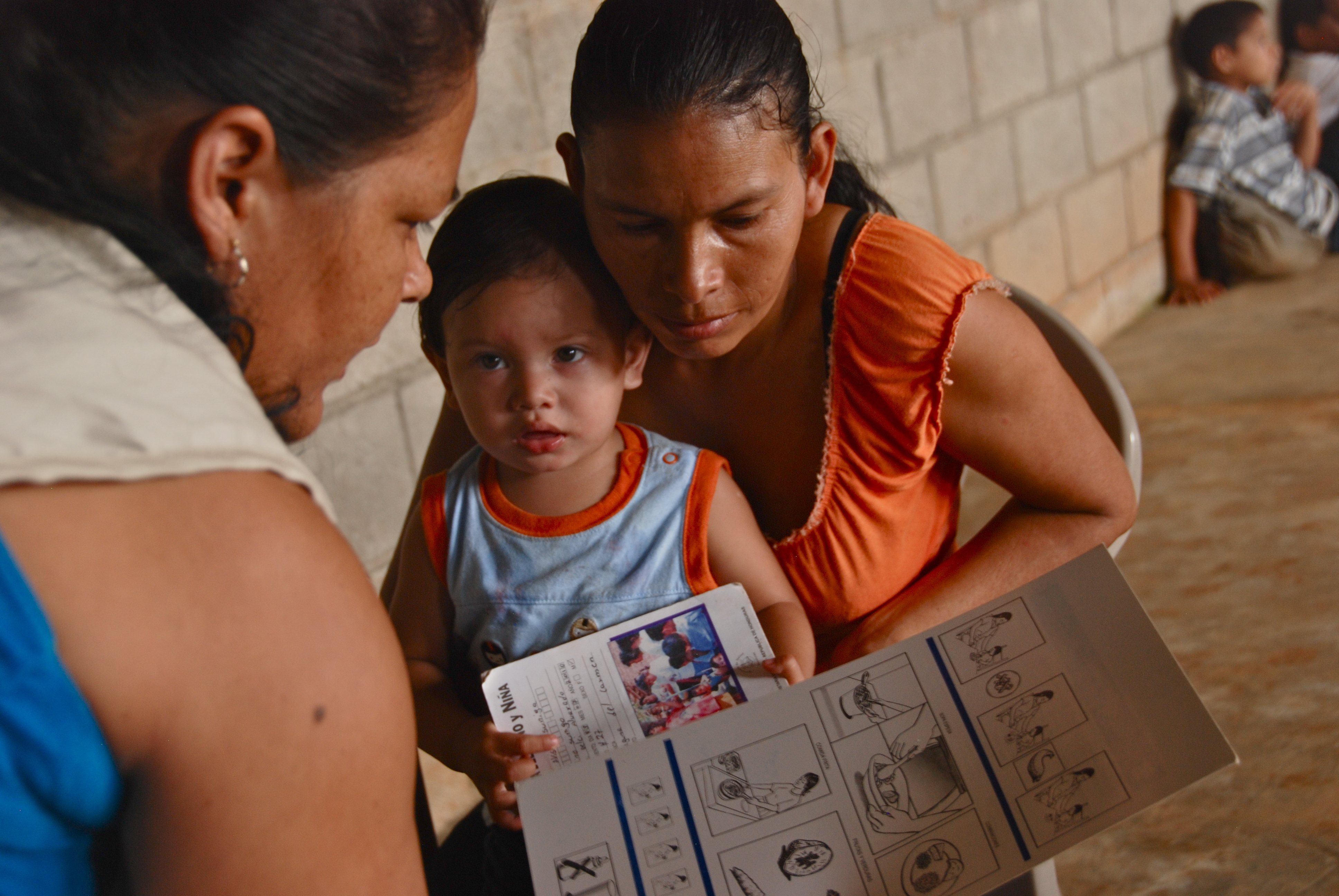 A Bolivian Red Cross volunteer teaches a Bolivian woman about child nutrition, part of a program to reduce deaths of children under 5.