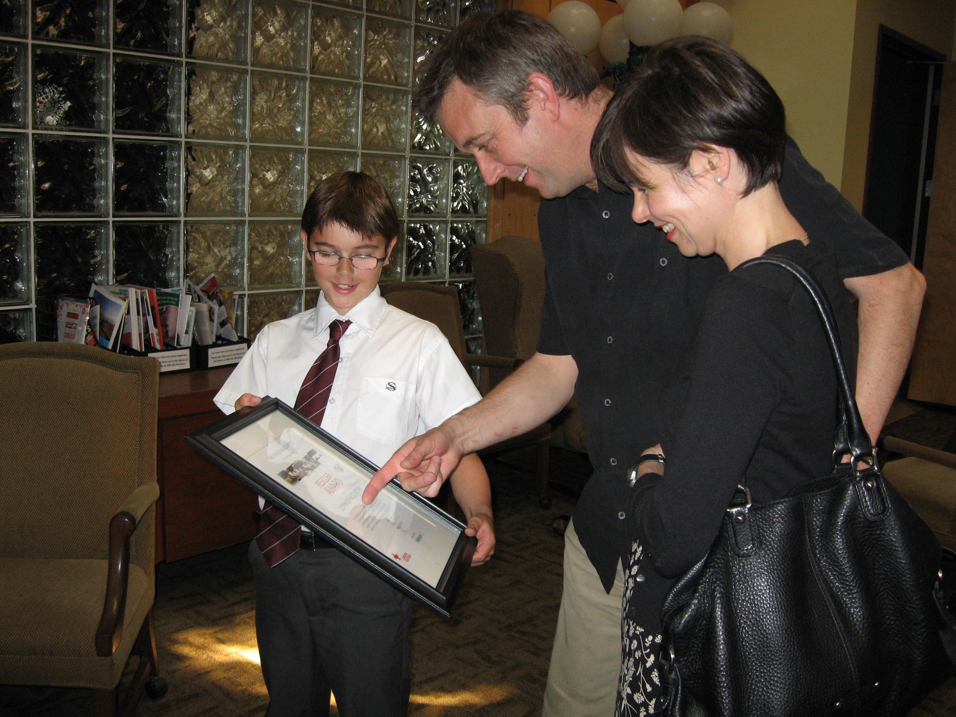 Connor and his parents Ian and Jane admire their son's Rescuer Award.