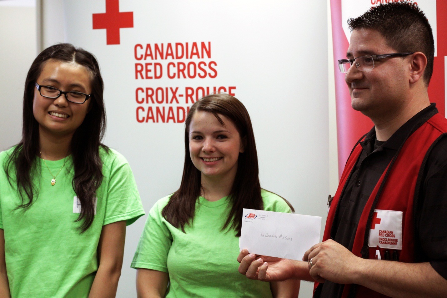 Helen Tu and Carrie Rhode present a cheque to Canadian Red Cross Fund Development Officer Andres Gutierrez