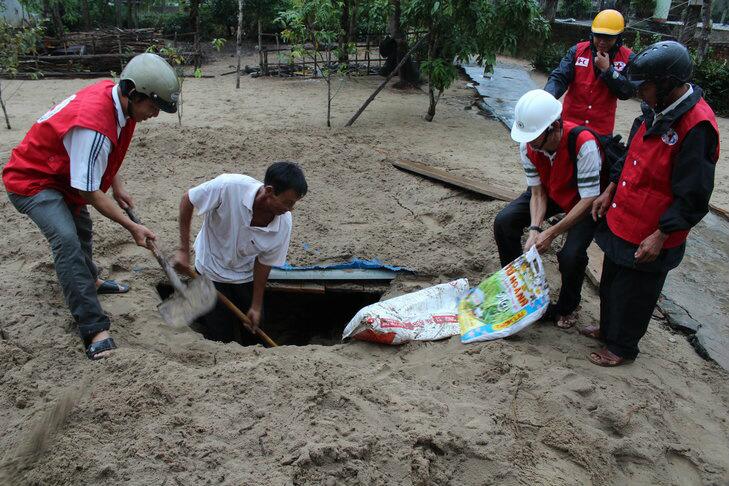 Vietnam Red Cross staff helping people prepare for Typhoon Haiyan by protecting valuables underground. 